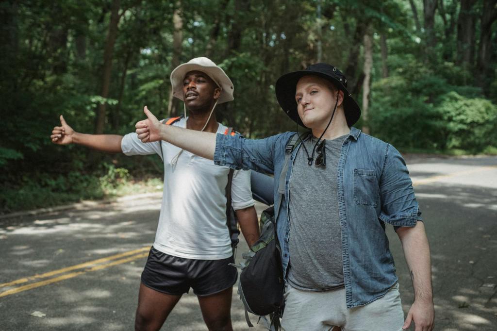 Two guys are hitchhiking.